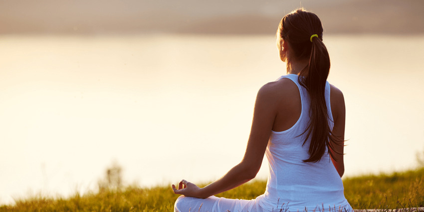 Persona realizando una postura tranquila de yoga en un ambiente luminoso